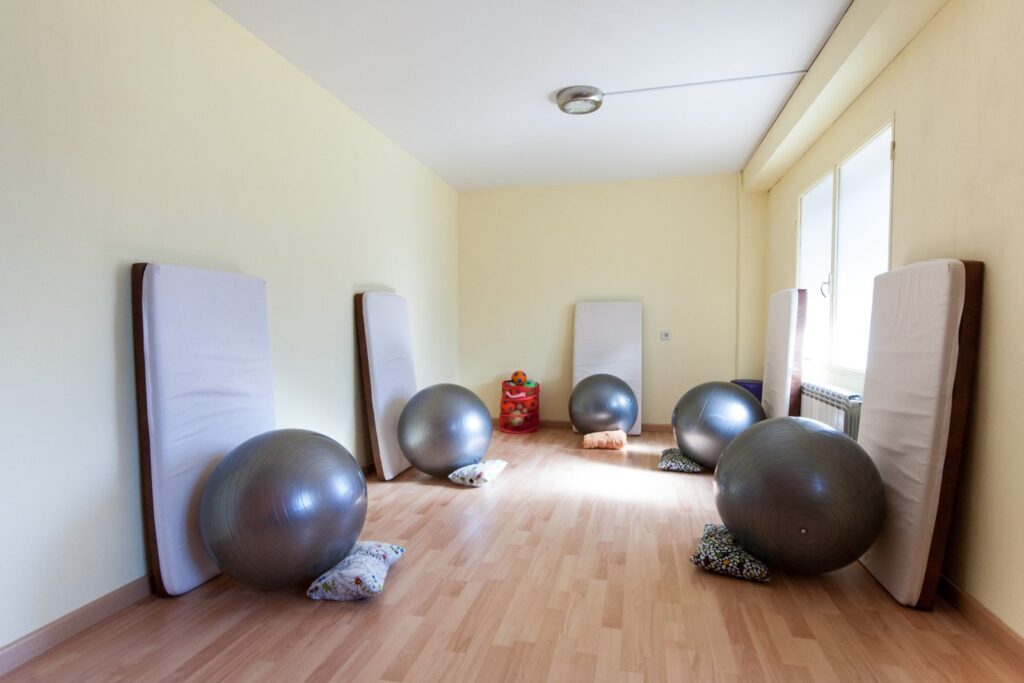 Sala de ejercicio terapéutico con fitballs y colchonetas en FisioBustar, Bustarviejo